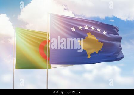 Sonniger blauer Himmel und Flaggen von kosovo und algerien Stockfoto