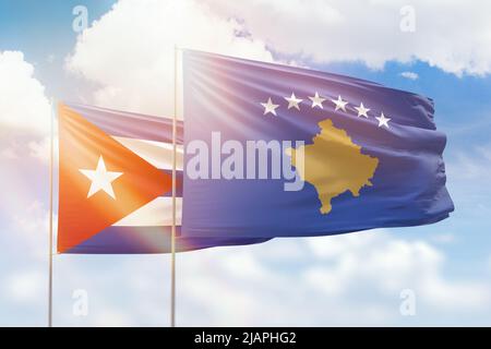 Sonniger blauer Himmel und Flaggen von kosovo und kuba Stockfoto