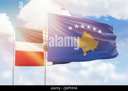 Sonniger blauer Himmel und Flaggen des kosovo und der dominikanischen republik Stockfoto