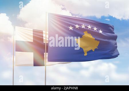 Sonniger blauer Himmel und Flaggen von kosovo und finnland Stockfoto