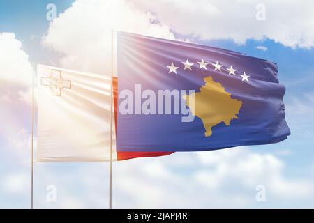 Sonniger blauer Himmel und Flaggen von kosovo und malta Stockfoto