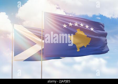 Sonniger blauer Himmel und Flaggen von kosovo und schottland Stockfoto