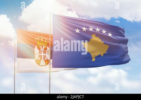 Sonniger blauer Himmel und Flaggen von kosovo und serbien Stockfoto