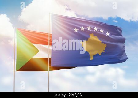 Sonniger blauer Himmel und Flaggen des kosovo und des sudan Stockfoto