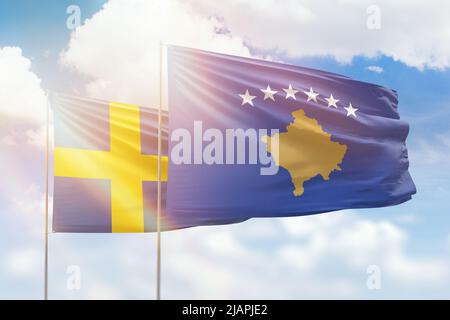 Sonniger blauer Himmel und Flaggen von kosovo und schweden Stockfoto