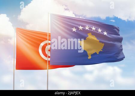 Sonniger blauer Himmel und Flaggen des kosovo und tunesiens Stockfoto