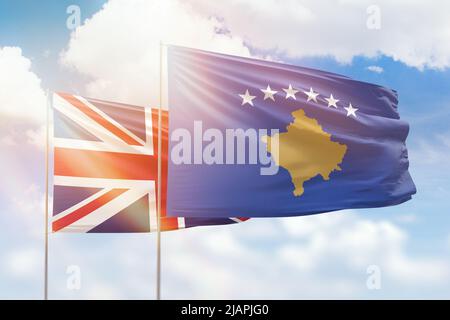 Sonniger blauer Himmel und Flaggen des kosovo und des vereinigten Königreichs Stockfoto