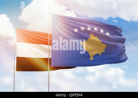 Sonniger blauer Himmel und Flaggen von kosovo und jemen Stockfoto