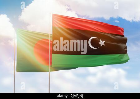 Sonniger blauer Himmel und Flaggen libyens und bangladeschs Stockfoto