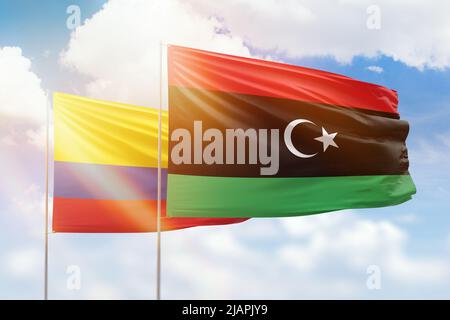 Sonniger blauer Himmel und Flaggen von libyen und kolumbien Stockfoto