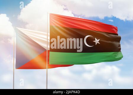 Sonniger blauer Himmel und Flaggen von libyen und tschechien Stockfoto