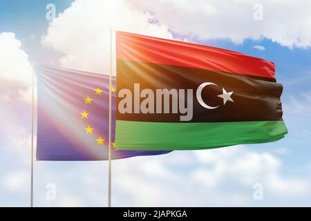 Sonniger blauer Himmel und Flaggen libyens und der europäischen Union Stockfoto