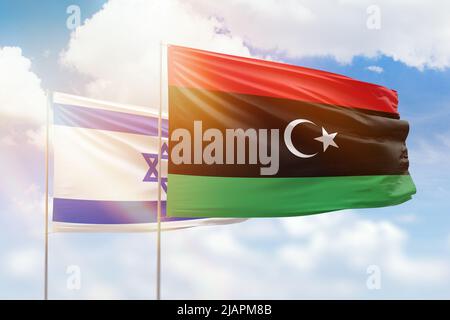 Sonniger blauer Himmel und Flaggen von libyen und israel Stockfoto