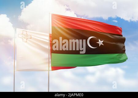 Sonniger blauer Himmel und Flaggen von libyen und malta Stockfoto