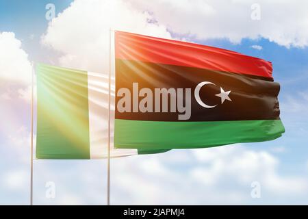 Sonniger blauer Himmel und Flaggen von libyen und nigeria Stockfoto