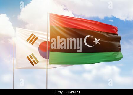 Sonniger blauer Himmel und Flaggen von libyen und Südkorea Stockfoto