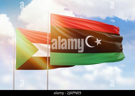 Sonniger blauer Himmel und Flaggen von libyen und dem sudan Stockfoto