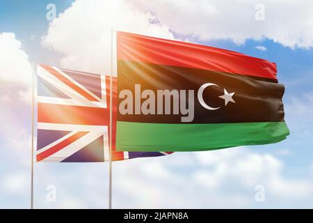 Sonniger blauer Himmel und Flaggen von libyen und dem vereinigten Königreich Stockfoto