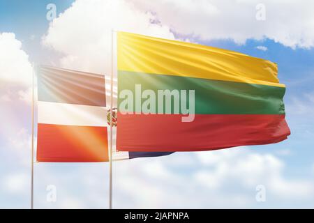 Sonniger blauer Himmel und Flaggen von litauen und der dominikanischen republik Stockfoto