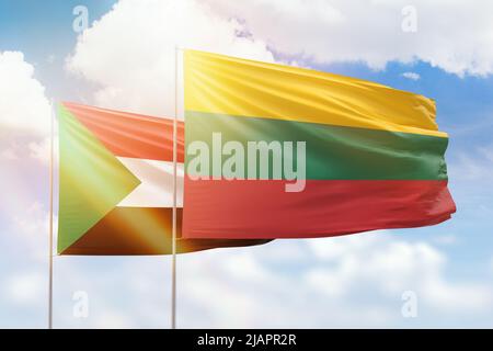 Sonniger blauer Himmel und Flaggen von litauen und sudan Stockfoto