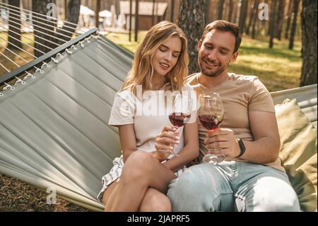 Attraktives junges romantisches Paar, das Rotwein trinkt Stockfoto
