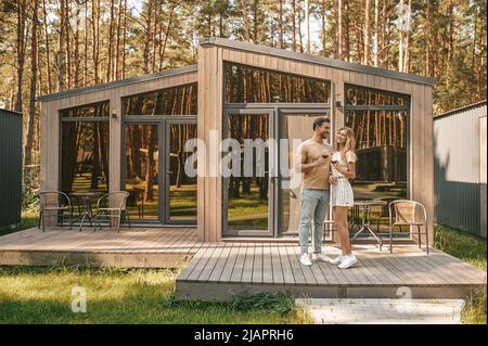 Ein Paar mit Gläsern Rotwein auf der Veranda Stockfoto