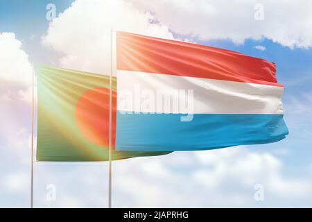 Sonniger blauer Himmel und Flaggen von luxemburg und bangladesch Stockfoto