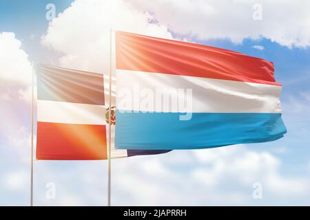 Sonniger blauer Himmel und Flaggen von luxemburg und der dominikanischen republik Stockfoto