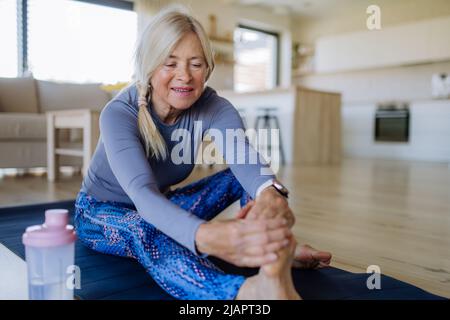 Fit Senior Frau macht Stretching-Übung zu Hause, aktive Lifestyle-Konzept. Stockfoto