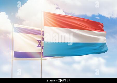 Sonniger blauer Himmel und Flaggen von luxemburg und israel Stockfoto