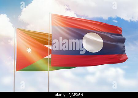 Sonniger blauer Himmel und Flaggen von laos und jordanien Stockfoto