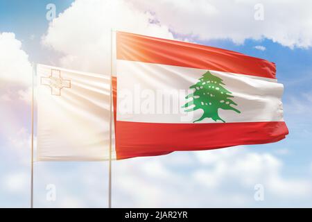 Sonniger blauer Himmel und Flaggen von libanon und malta Stockfoto