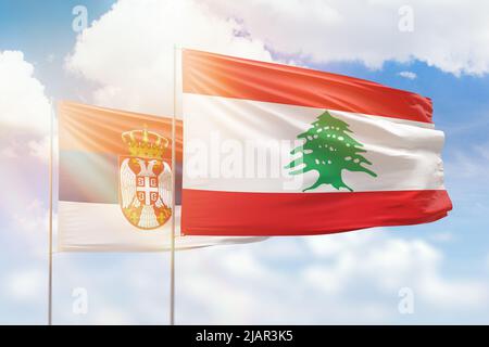 Sonniger blauer Himmel und Flaggen des libanon und serbiens Stockfoto