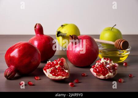 Inschrift mit Gratulation mit Rosh Hashanah, traditionellen Granatäpfeln, grünen Äpfeln und Honig. Jüdisches Neujahr. Herzlichen Glückwunsch. Selektiver Fokus Stockfoto