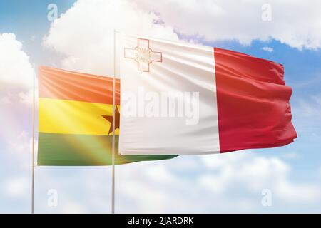 Sonniger blauer Himmel und Flaggen von malta und ghana Stockfoto