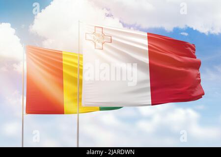 Sonniger blauer Himmel und Flaggen von malta und Meerschweinchen Stockfoto