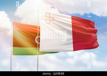 Sonniger blauer Himmel und Flaggen von malta und libyen Stockfoto