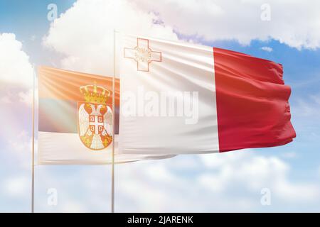 Sonniger blauer Himmel und Flaggen von malta und serbien Stockfoto