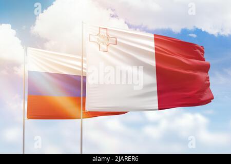 Sonniger blauer Himmel und Flaggen von malta und russland Stockfoto