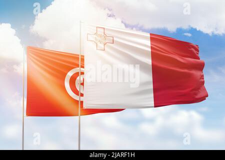 Sonniger blauer Himmel und Flaggen von malta und tunesien Stockfoto