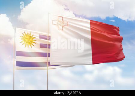 Sonniger blauer Himmel und Flaggen von malta und uruguay Stockfoto