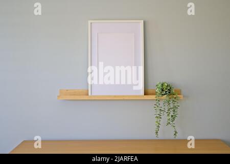 Innenrahmen-Modell mit leerem Rahmen auf einem Holzregal Stockfoto