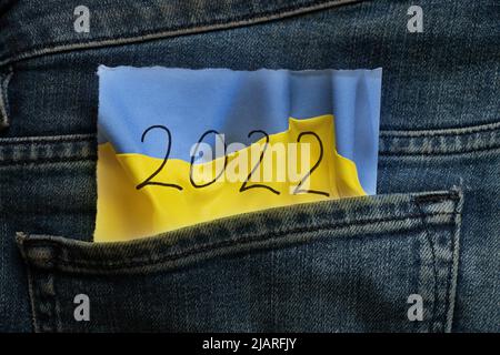 Die Flagge der Ukraine und der Text 2022 sind auf einer Papierkarte in einer Jeanstasche gezeichnet, Mode und Trend, der Krieg in der Ukraine im Jahr 2022 Stockfoto