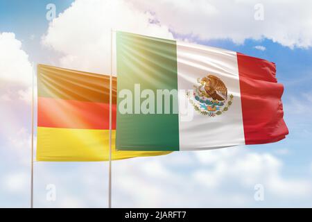 Sonniger blauer Himmel und Flaggen von mexiko und deutschland Stockfoto