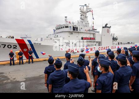 Manila, Philippinen. 1.. Juni 2022. Mitglieder der philippinischen Küstenwache begrüßen die Ankunft des BRP Melchora Aquino im Hafengebiet von Manila auf den Philippinen. 1. Juni 2022. Das brandneue, von Japan gebaute Mehrzweckschiff wurde von der Küstenwache beauftragt, seine Fähigkeiten im Bereich der maritimen Sicherheit, Sicherheit und des marinen Umweltschutzes in den Gewässern des Landes zu stärken, insbesondere im umstrittenen Südchinesischen Meer, wo die Philippinen weiterhin angespannte territoriale Auseinandersetzungen mit China haben. (Bild: © Basilio Sepe/ZUMA Press Wire) Stockfoto