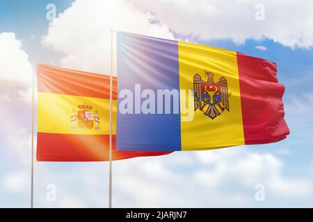 Sonniger blauer Himmel und Flaggen von moldawien und spanien Stockfoto