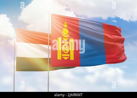 Sonniger blauer Himmel und Flaggen der mongolei und ungarns Stockfoto