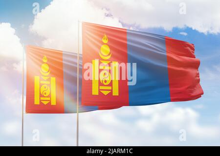 Sonniger blauer Himmel und Flaggen der mongolei und der mongolei Stockfoto