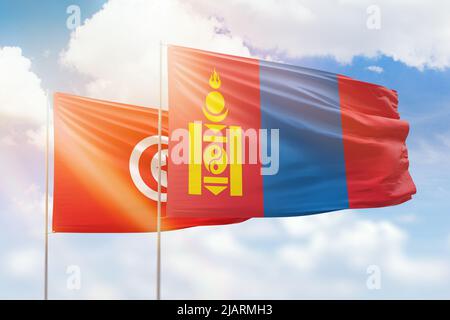 Sonniger blauer Himmel und Flaggen der mongolei und tunesiens Stockfoto