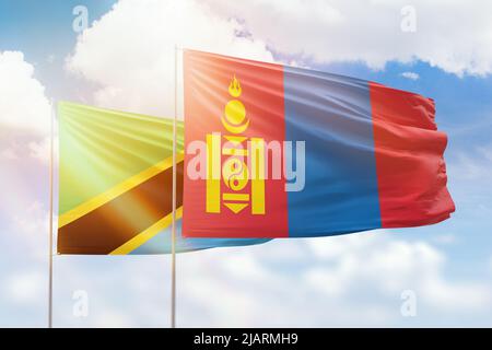 Sonniger blauer Himmel und Flaggen der mongolei und tansanias Stockfoto